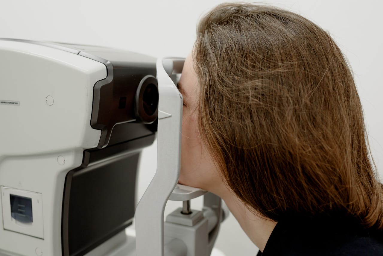A woman receives an eye exam using advanced medical equipment at a clinic.